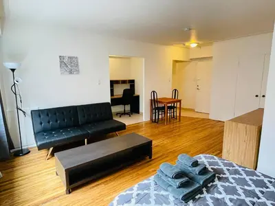 a living room with a black couch and a table at Stylish Montreal Apartment: Comfortable Stay in the Golden Square Mile in Montréal