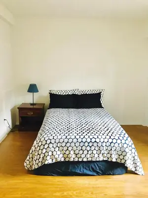 a bed with a black and white comforter in a room at Stylish Montreal Apartment: Comfortable Stay in the Golden Square Mile in Montréal