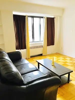 a living room with a black leather couch and a coffee table at Stylish Montreal Apartment: Comfortable Stay in the Golden Square Mile in Montréal