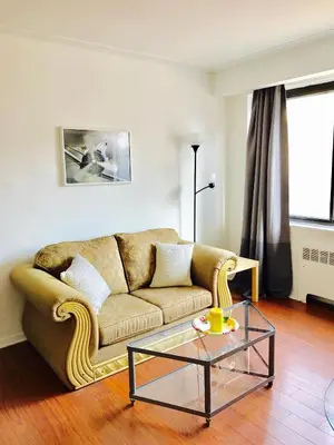 a living room with a couch and a glass table at Stylish Montreal Apartment: Comfortable Stay in the Golden Square Mile in Montréal