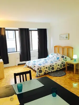 a bedroom with a bed and a table with a table sidx sidx sidx at Stylish Montreal Apartment: Comfortable Stay in the Golden Square Mile in Montréal