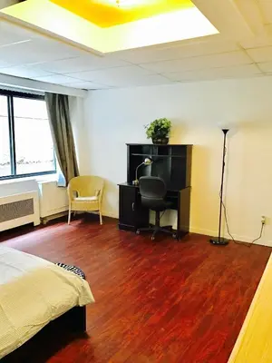 a bedroom with a bed and a desk with a computer at Stylish Montreal Apartment: Comfortable Stay in the Golden Square Mile in Montréal