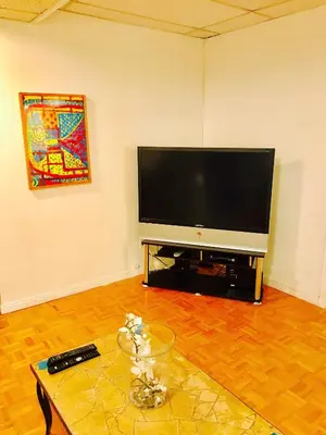 a living room with a flat screen tv and a table at Stylish Montreal Apartment: Comfortable Stay in the Golden Square Mile in Montréal