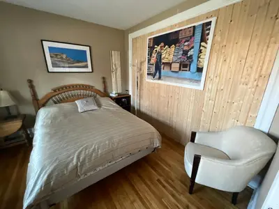 a bedroom with a bed and a chair at L'Oasis Des Nomades in Trois-Rivières