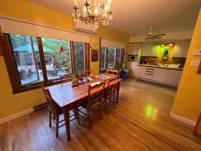 a dining room with a wooden table and chairs at L'Oasis Des Nomades in Trois-Rivières