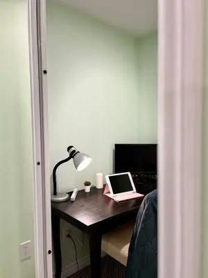 a desk with a laptop and a lamp on it at Logement complet, proche métro, parking gratuit in Montréal