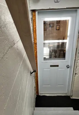 a white door in a room with a table at Logement complet, proche métro, parking gratuit in Montréal