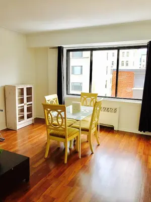 a dining room with a table with chairs and a laptop at Stylish Montreal Apartment: Comfortable Stay in the Golden Square Mile in Montréal