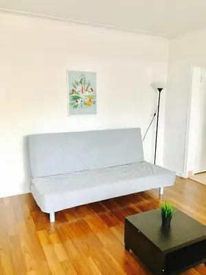 a white couch in a white room with a table at Stylish Montreal Apartment: Comfortable Stay in the Golden Square Mile in Montréal