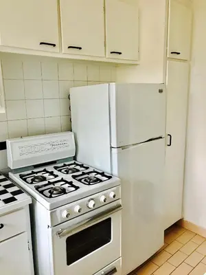 a kitchen with a white stove and a refrigerator at Stylish Montreal Apartment: Comfortable Stay in the Golden Square Mile in Montréal