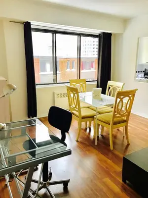 a living room with a table and chairs and a window at Stylish Montreal Apartment: Comfortable Stay in the Golden Square Mile in Montréal