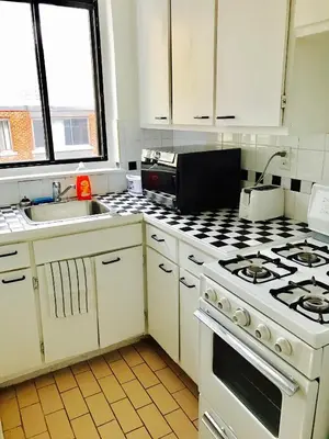 a kitchen with white cabinets and a stove top oven at Stylish Montreal Apartment: Comfortable Stay in the Golden Square Mile in Montréal