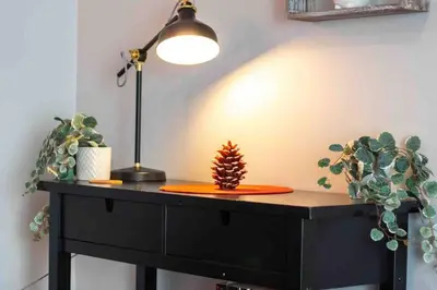 a black desk with a lamp and a plant on it at Chalet BIA - Le Petit Chaleureux in Ham Nord