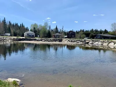 a body of water with houses in the background at Chalet BIA - Le Petit Chaleureux in Ham Nord