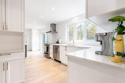 a white kitchen with white cabinets and a sink at lacbrome Chalet lake+Terrasse+BBQ+Hot-tub in Lac-Brome