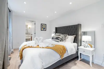 a bedroom with a large bed with a black headboard at lacbrome Chalet lake+Terrasse+BBQ+Hot-tub in Lac-Brome