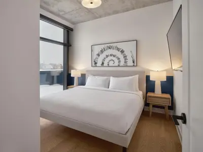 a bedroom with a white bed and a window at Hôtel Expérience - Quartier Des Marinas in Magog-Orford