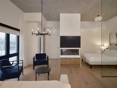 a living room with a bed and a fireplace at Hôtel Expérience - Quartier Des Marinas in Magog-Orford