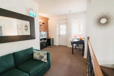 a living room with a green couch and a table at Bed and Breakfast du Village BBV in Montréal