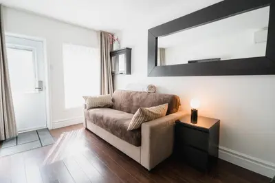 a living room with a couch and a mirror at Bed and Breakfast du Village BBV in Montréal