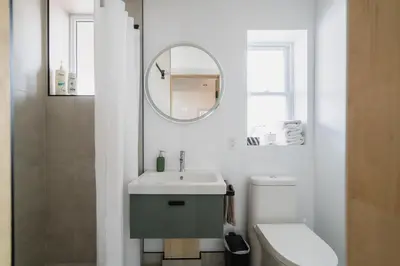 a bathroom with a sink and a mirror and a toilet at Bed and Breakfast du Village BBV in Montréal