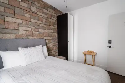 a bedroom with a brick wall and a bed at Bed and Breakfast du Village BBV in Montréal