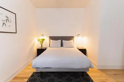 a bedroom with a bed and two night stands at Bed and Breakfast du Village BBV in Montréal