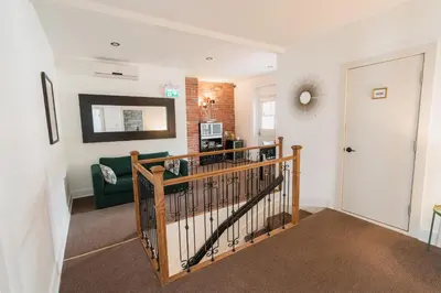 a living room with a staircase leading to a living room at Bed and Breakfast du Village BBV in Montréal