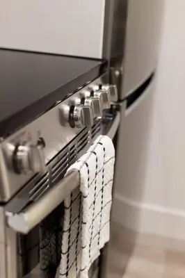 a close up of a stove with towels on it at 6768 - 102 Cozy and Fresh Mini Studio with kitchen by Denstays in Montréal