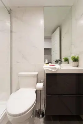 a white bathroom with a toilet and a sink at 6768 - 102 Cozy and Fresh Mini Studio with kitchen by Denstays in Montréal
