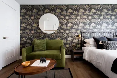 a bedroom with a bed and a green chair and a mirror at 6768 - 202 Amazing mini studio with full kitchen by Denstays in Montréal