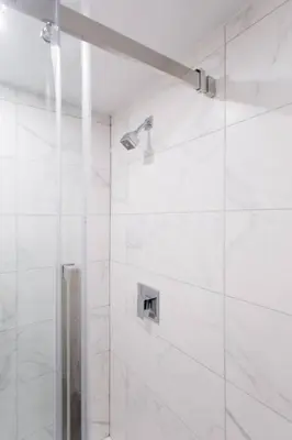 a bathroom with a shower with white tiles at 6768 - 202 Amazing mini studio with full kitchen by Denstays in Montréal