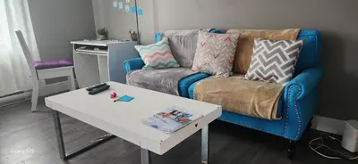 a living room with a couch and a table at Maison chaleureuse, énergétique et florale in Sherbrooke