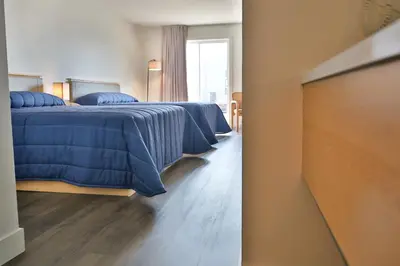 a bedroom with two beds and a tv in it at Motel Mascouche in Mascouche
