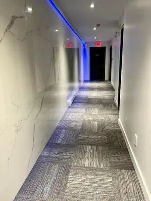 a hallway with a long hallway with a blue light at Motel Mascouche in Mascouche