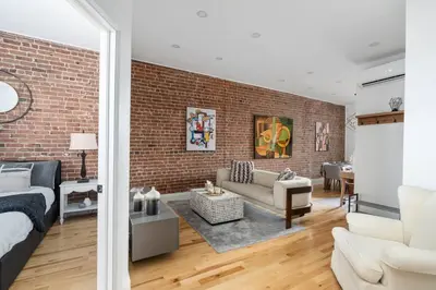 a living room with a brick wall and a couch at Downtown Luxe: Metro, King Bed, Parking, Sleeps 6 in Montréal