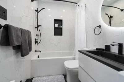 a white bathroom with a tub and a sink and a toilet at Downtown Luxe: Metro, King Bed, Parking, Sleeps 6 in Montréal