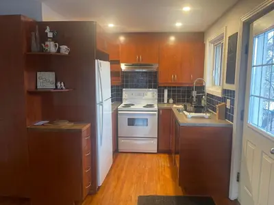 a kitchen with a white stove and a refrigerator at Appartement près du Métro in Laval