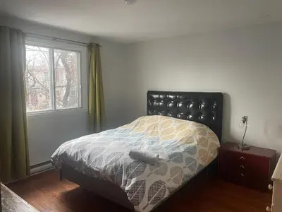 a bedroom with a bed and a window at Appartement près du Métro in Laval