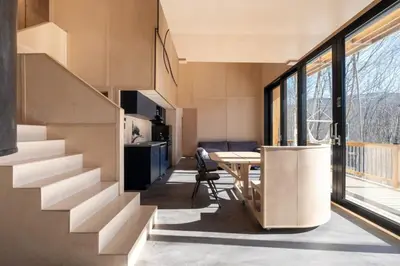 a house with a staircase and a table in a room at Cabin Zoobox 47 in Eastman