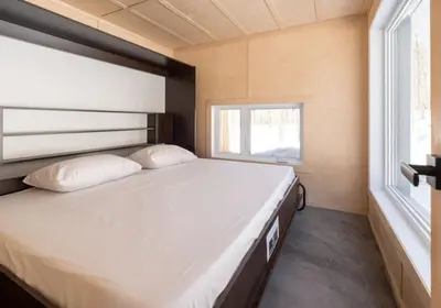 a large bed in a small room with a window at Cabin Zoobox 47 in Eastman