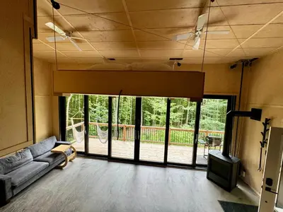 a living room with a couch and a large glass door at Cabin Zoobox 47 in Eastman