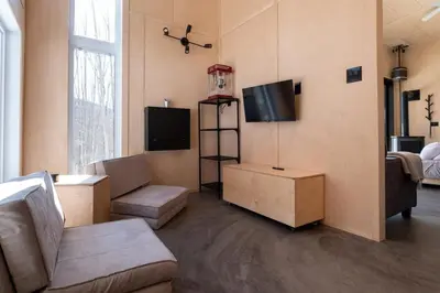 a living room with a couch and a tv at Cabin Zoobox 47 in Eastman