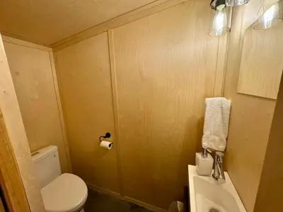 a small bathroom with a toilet and a sink at Cabin Zoobox 47 in Eastman
