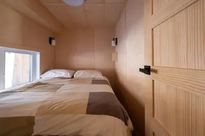 a bedroom with a bed in a room with a door at Cottage Zoobox-style 51 in Eastman