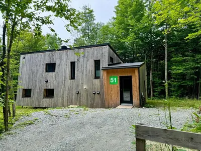a large wooden building with a sign on it at Cottage Zoobox-style 51 in Eastman