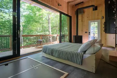 a bedroom with a bed and a large window at Cabin Zoobox 57 in Eastman