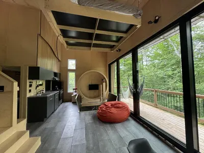 a living room with a large window and a deck at Cabin Zoobox 63 in Eastman