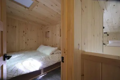 a small bedroom with a bed in a wooden wall at Cabin Zoobox 69 in Eastman