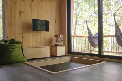 a living room with a tv on the wall and a rug at Cabin Zoobox 69 in Eastman